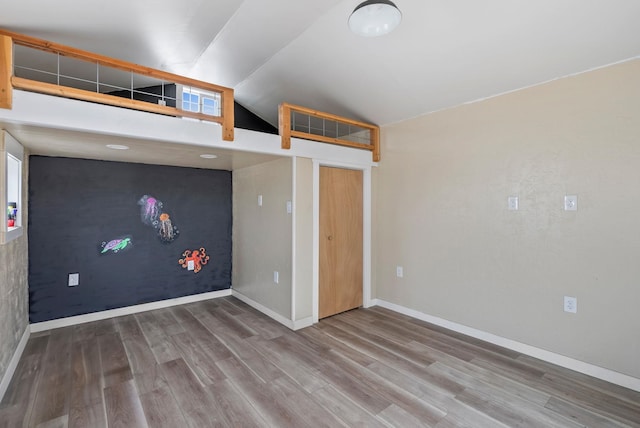 interior space with wood-type flooring and vaulted ceiling