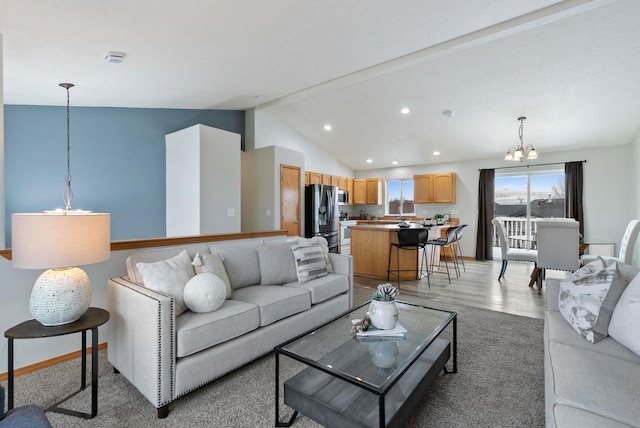 living room featuring hardwood / wood-style flooring, a notable chandelier, and lofted ceiling with beams