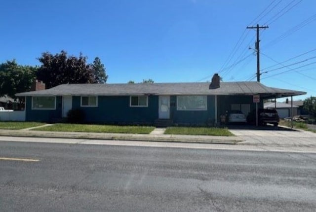 ranch-style house with a carport and a front lawn