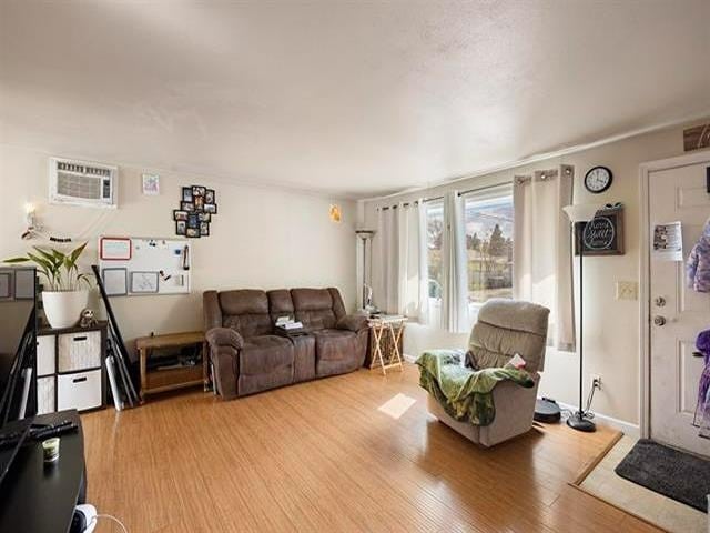 living room featuring light hardwood / wood-style flooring and a wall mounted air conditioner