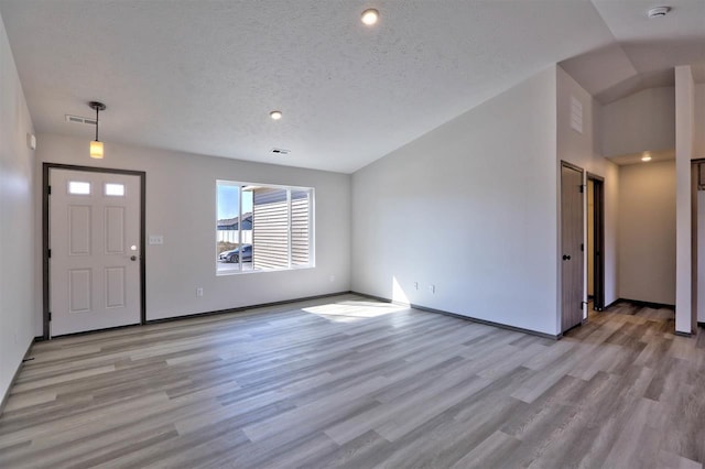 entryway featuring a textured ceiling and light hardwood / wood-style flooring