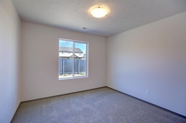 carpeted spare room with a textured ceiling