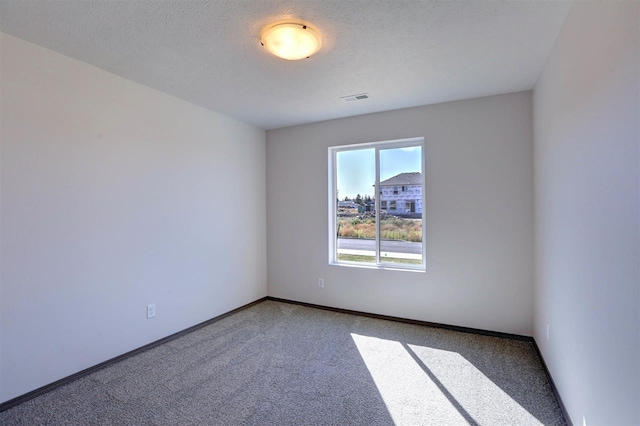 carpeted spare room featuring a textured ceiling