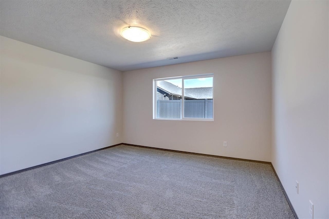 unfurnished room featuring carpet and a textured ceiling