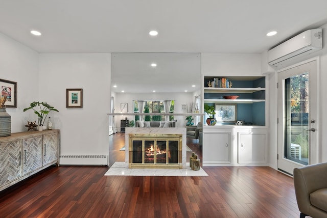 living room featuring a fireplace, a baseboard radiator, a wall mounted AC, and dark wood-type flooring