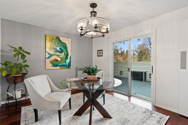 dining room with dark hardwood / wood-style flooring and a notable chandelier