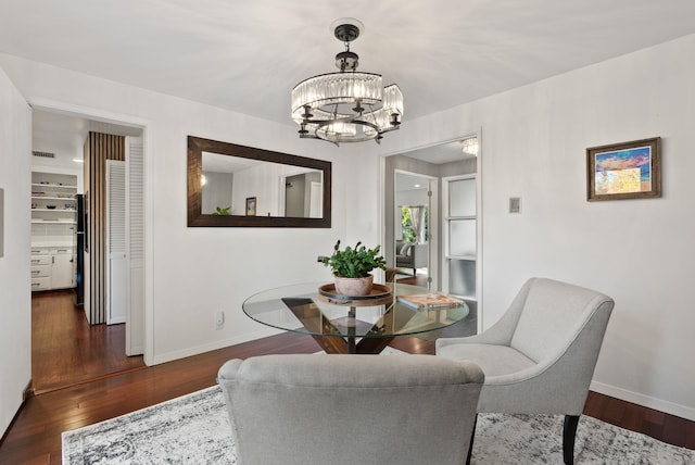 dining area featuring an inviting chandelier and dark wood-type flooring