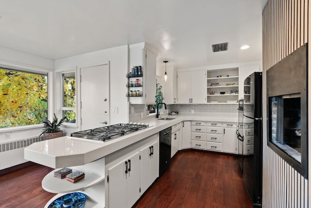 kitchen featuring pendant lighting, radiator, black appliances, white cabinets, and sink