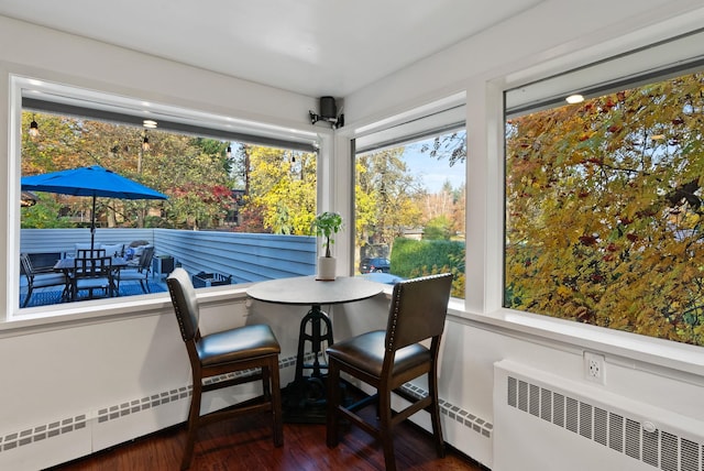 sunroom / solarium featuring a wealth of natural light, baseboard heating, and radiator