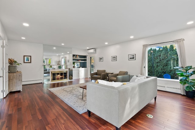 living room featuring a baseboard radiator, a wall unit AC, and dark hardwood / wood-style floors