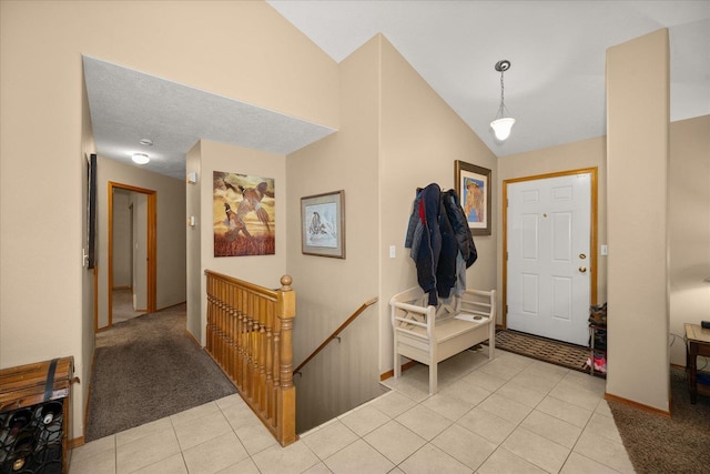 tiled entryway featuring vaulted ceiling