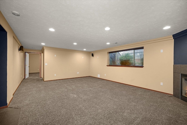 basement featuring carpet flooring, a fireplace, and a textured ceiling