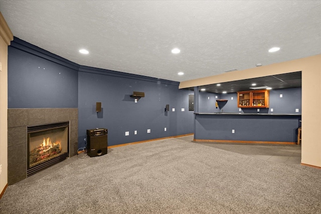 cinema featuring light colored carpet, a textured ceiling, and a tiled fireplace