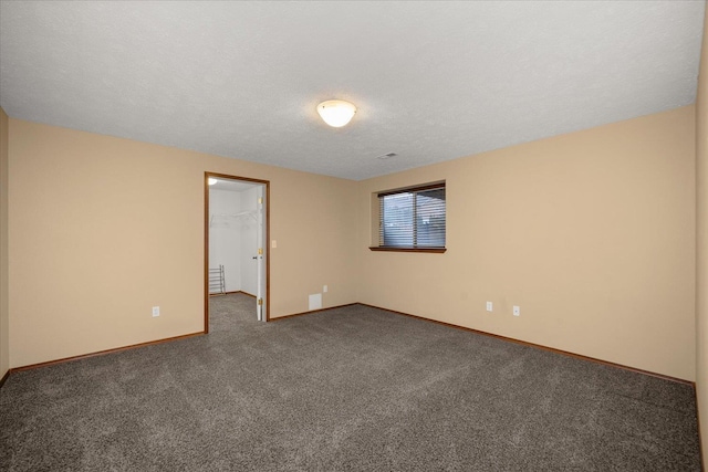 spare room with dark colored carpet