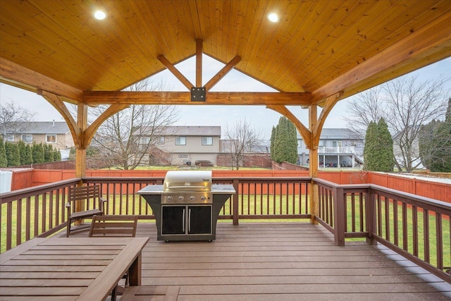 wooden terrace featuring a lawn and a grill