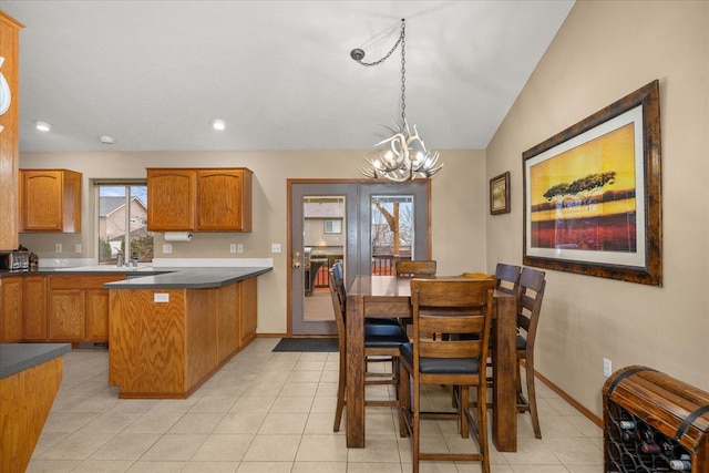 dining room with vaulted ceiling, a notable chandelier, and light tile patterned flooring