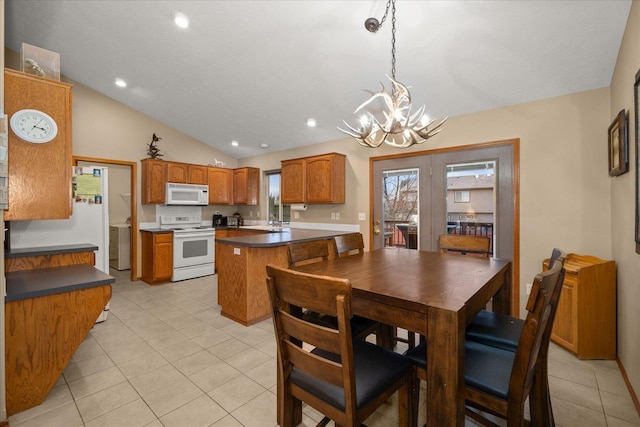 tiled dining space featuring a healthy amount of sunlight, lofted ceiling, sink, and a chandelier