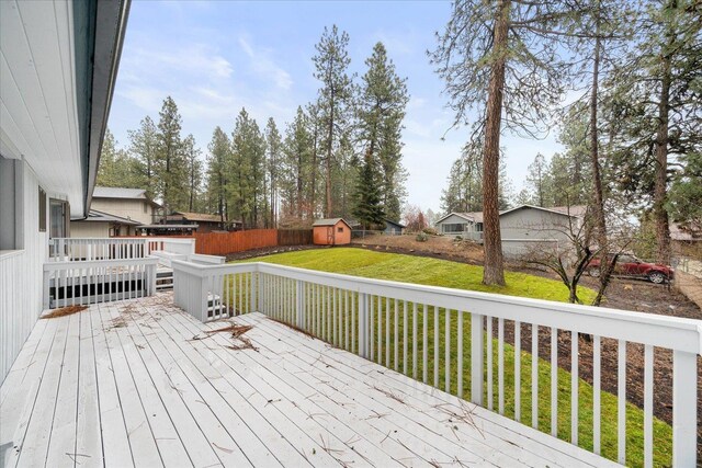 wooden deck featuring a yard and a storage unit