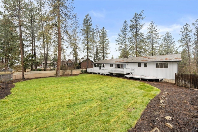 back of property with a lawn and a wooden deck