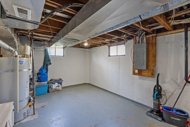 basement with plenty of natural light, strapped water heater, and electric panel