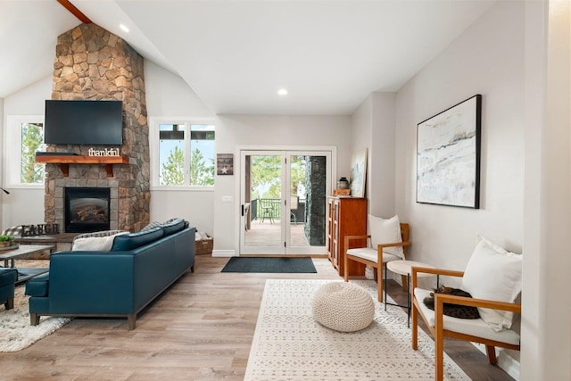 interior space with light hardwood / wood-style floors, a fireplace, and vaulted ceiling