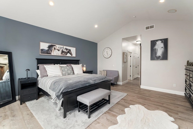 bedroom with light wood-type flooring and vaulted ceiling