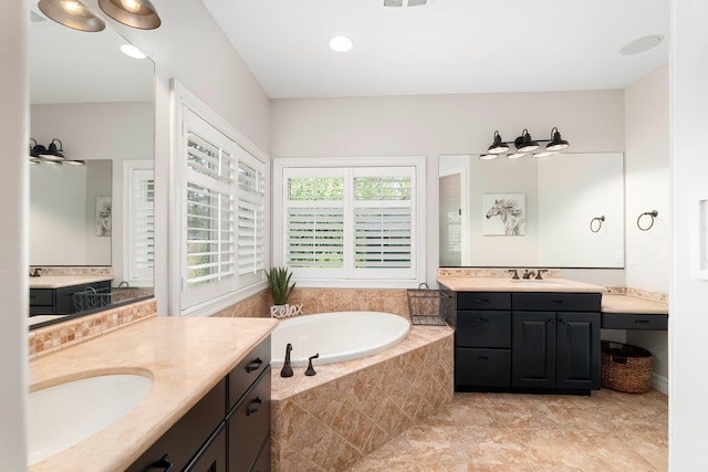 bathroom featuring vanity, ceiling fan, and tiled tub