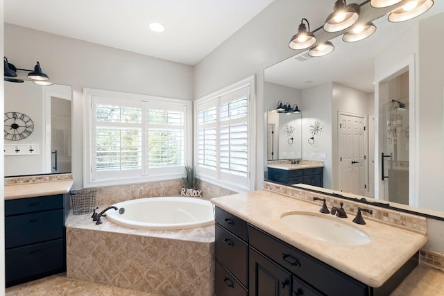 bathroom with vanity and shower with separate bathtub