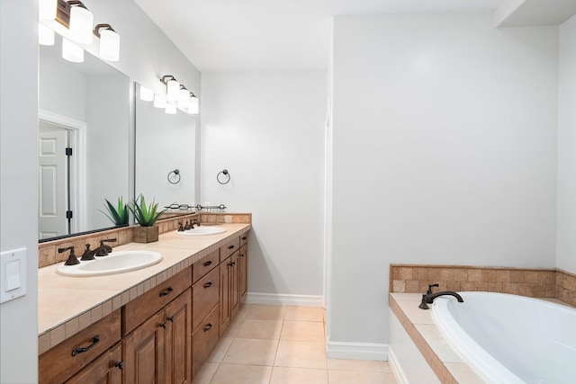 bathroom featuring tile patterned floors, vanity, and tiled bath