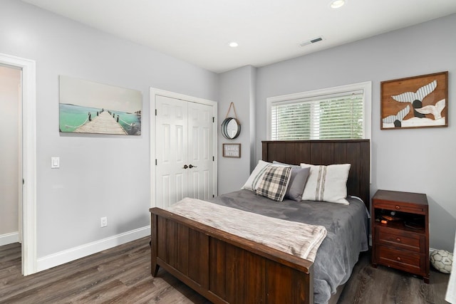 bedroom with dark hardwood / wood-style flooring and a closet