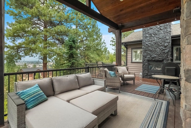 wooden terrace featuring an outdoor living space with a fireplace