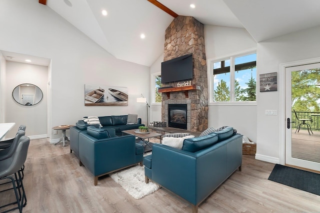 living room with a fireplace, light hardwood / wood-style floors, high vaulted ceiling, and a wealth of natural light