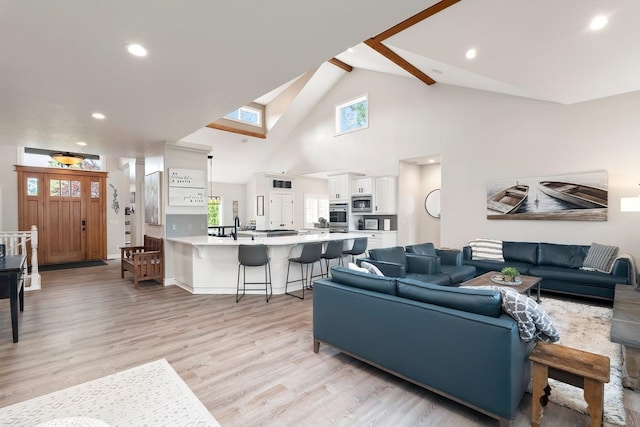 living room featuring light hardwood / wood-style floors and high vaulted ceiling