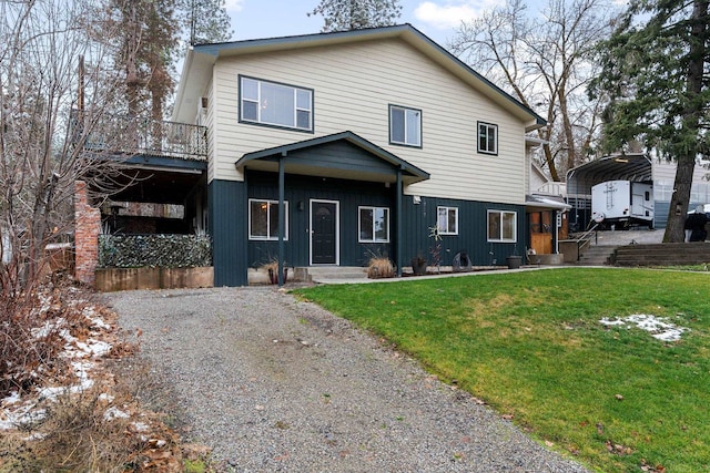 front facade with a front lawn and a carport