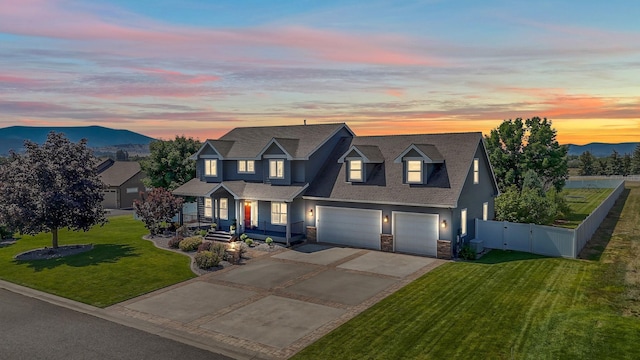 view of front of home featuring a mountain view, a garage, and a lawn