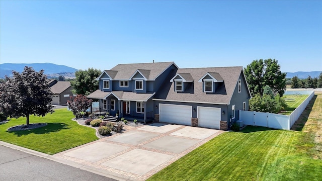 view of front of house with a mountain view, a garage, and a front lawn