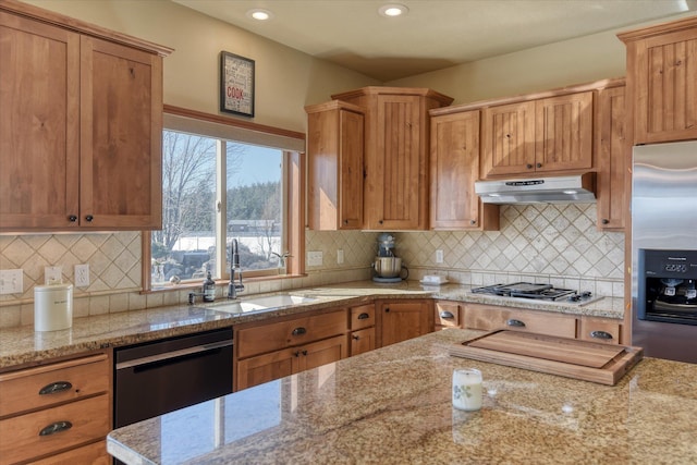 kitchen with decorative backsplash, light stone counters, sink, and appliances with stainless steel finishes