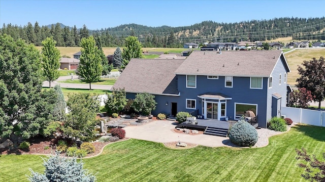 back of property featuring a patio, a deck, and a lawn