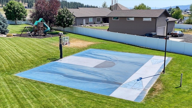 view of basketball court featuring a playground and a yard