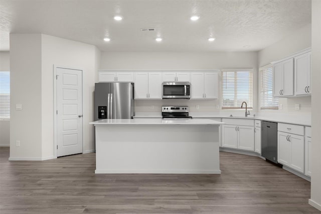 kitchen featuring a kitchen island, sink, white cabinetry, and stainless steel appliances