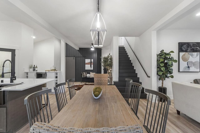 dining space with light hardwood / wood-style flooring and sink