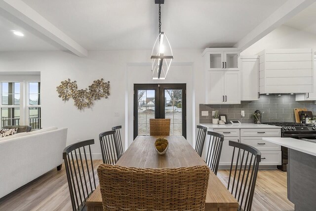 dining space featuring plenty of natural light, beamed ceiling, and light wood-type flooring