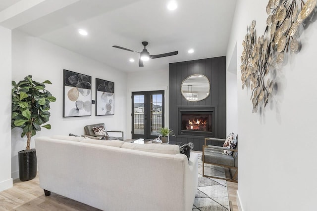 living room with a fireplace, light hardwood / wood-style flooring, and ceiling fan