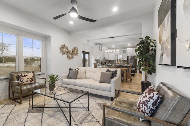 living room with ceiling fan, light wood-type flooring, and sink