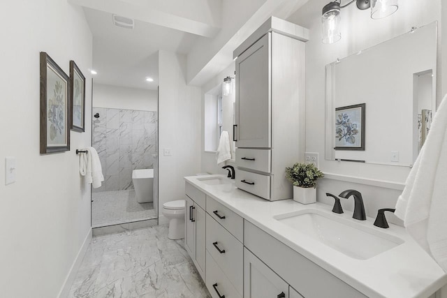 bathroom with toilet, vanity, and tiled shower