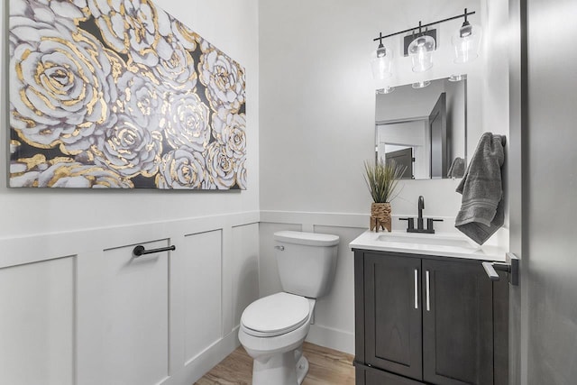 bathroom with hardwood / wood-style flooring, vanity, and toilet