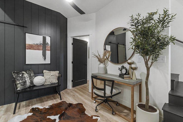 office space featuring light hardwood / wood-style flooring and wood walls