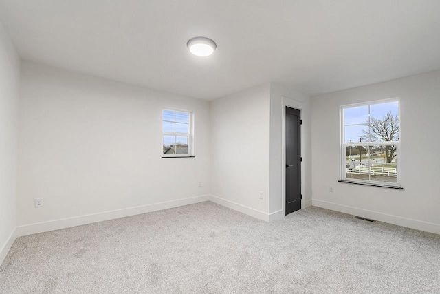 carpeted spare room featuring a healthy amount of sunlight