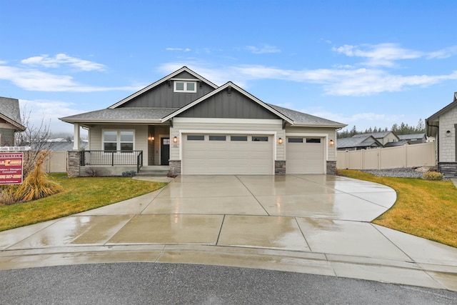 craftsman-style house featuring a garage, covered porch, and a front lawn