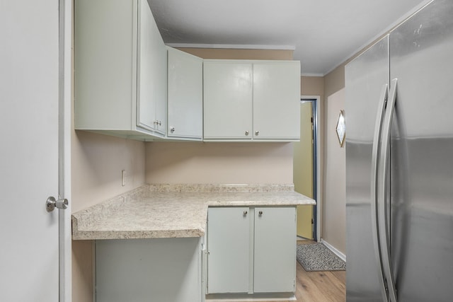 kitchen with stainless steel refrigerator and light hardwood / wood-style flooring